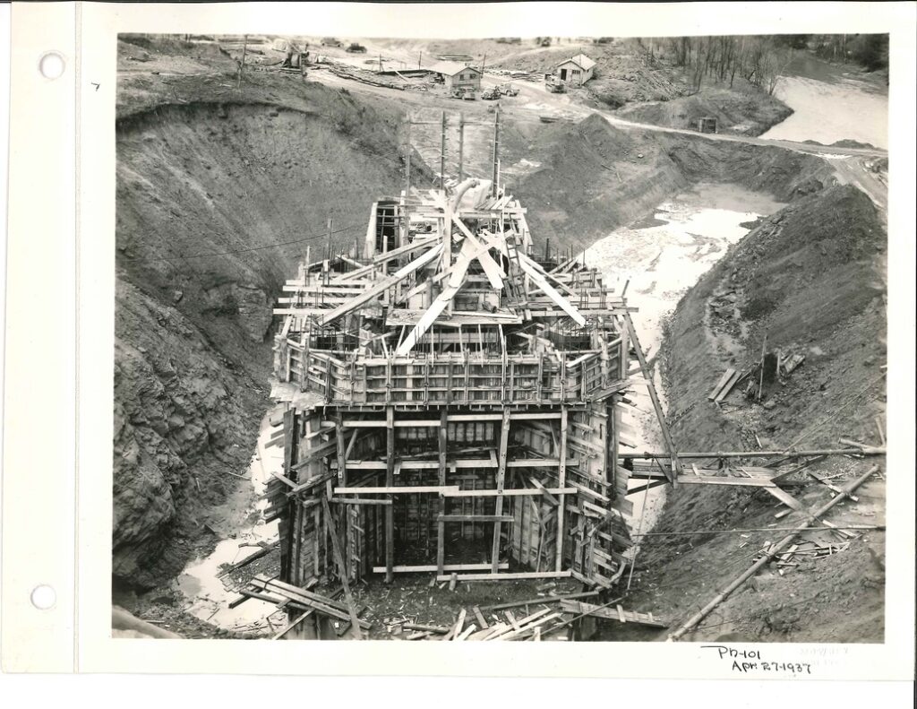 85 year old photo of the form work for construction of the morning glory spillway; wooden framework all around.